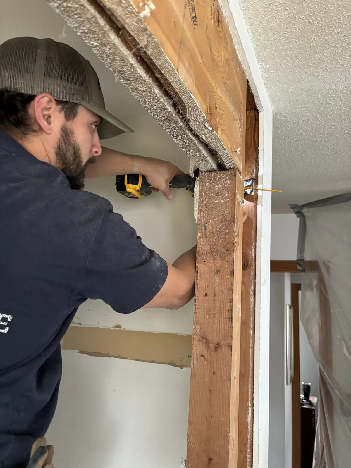 Cutting Edge crew member working on interior carpentry at a doorway