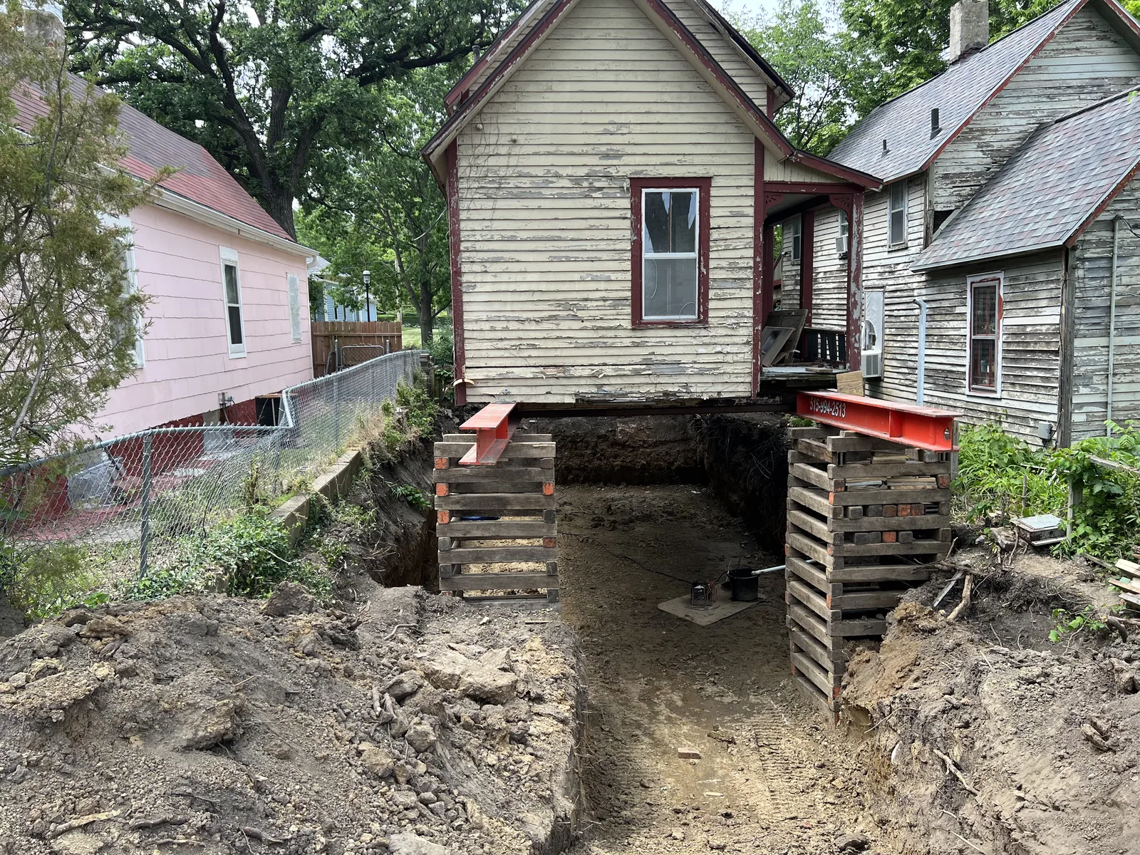 Historic Des Moines house raised on steel beams and timber cribbing during foundation replacement